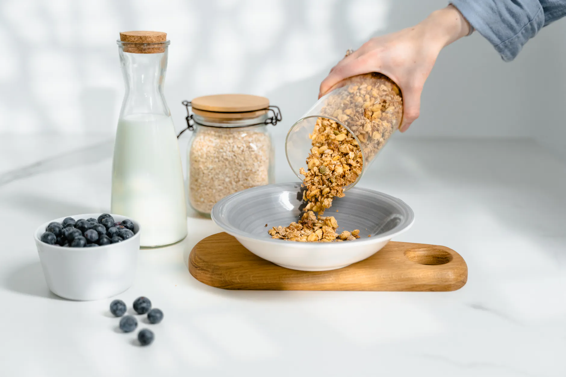 Golden brown crispy healthy granola with nuts and clusters in a ceramic bowl.